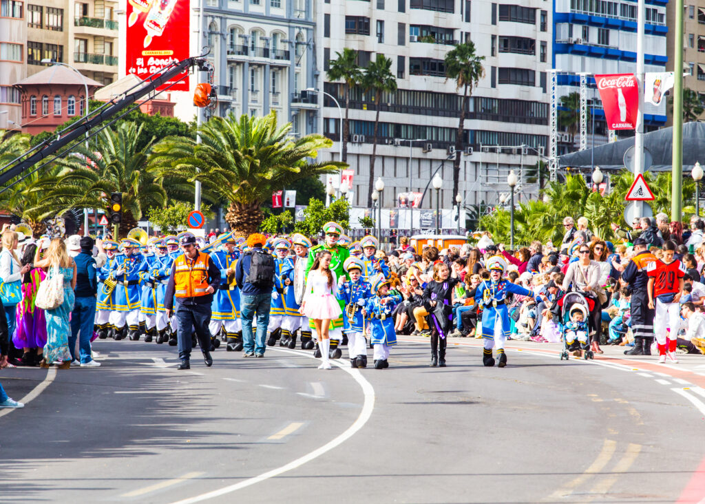 Masqueraders moving through the streets of Port of Spain during Trinidad Carnival road march, surrounded by music, sweat, and motion