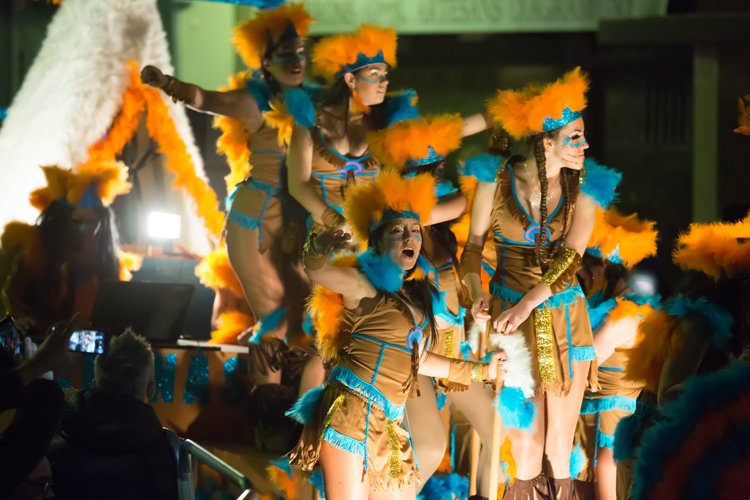 Wide shot of a Trinidad Carnival band moving together through Port of Spain, showing cohesion and shared rhythm