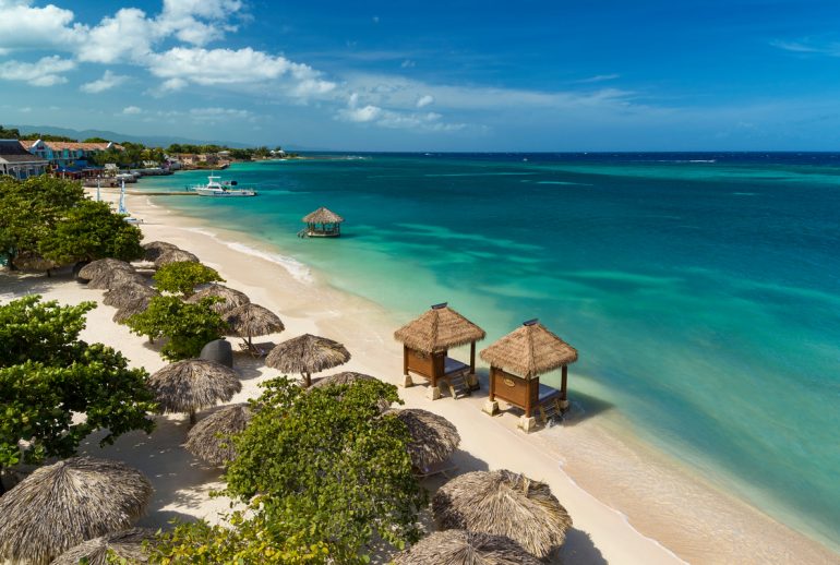 Quiet early morning beach in Jamaica with soft light and open space, reflecting the island’s natural pace of wellness