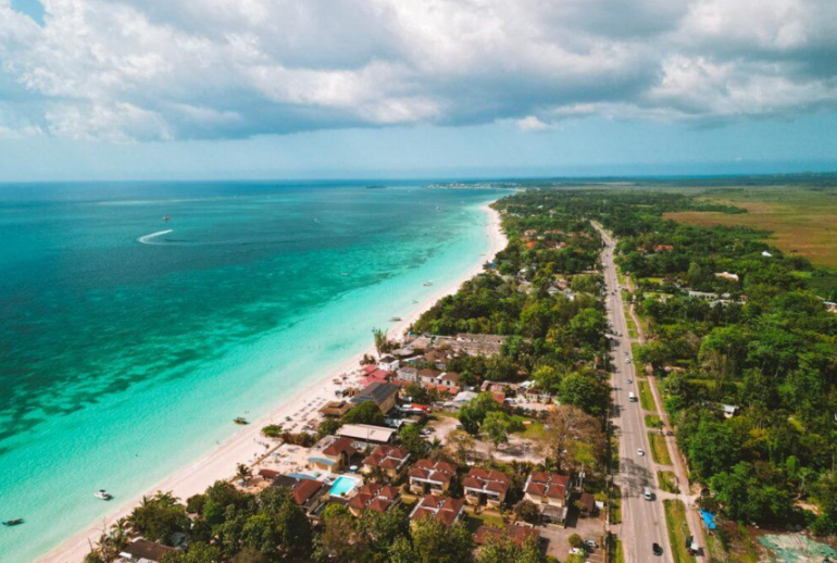 high aerial showing Long Bay, Norman Manley Boulevard, and the inland morass