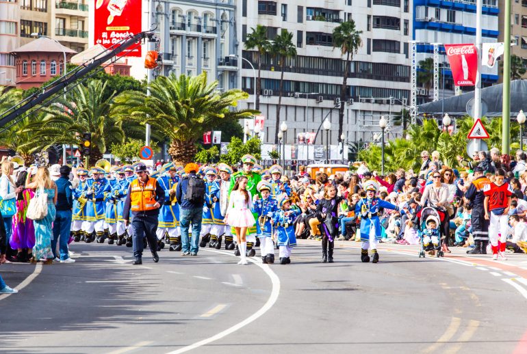 Masqueraders moving through the streets of Port of Spain during Trinidad Carnival road march, surrounded by music, sweat, and motion